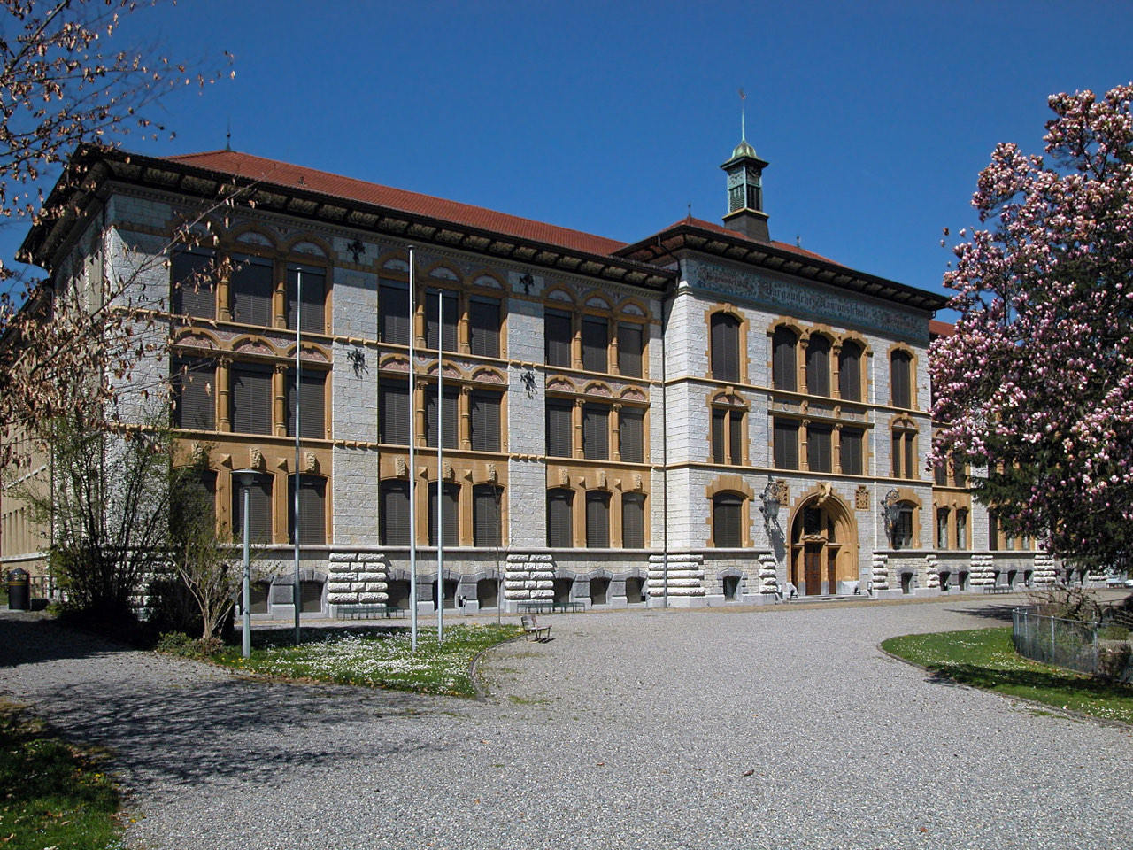 Das Hauptgebäude der Aargauischen Kantonsschule in Aarau, ein dreigeschossiger Bau mit gelb gefassten Fenstern und der Inschrift Aargauische Kantonsschule über dem Portal